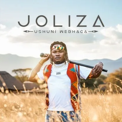 Joliza standing in a golden field holding a stick across the shoulders, under the album title